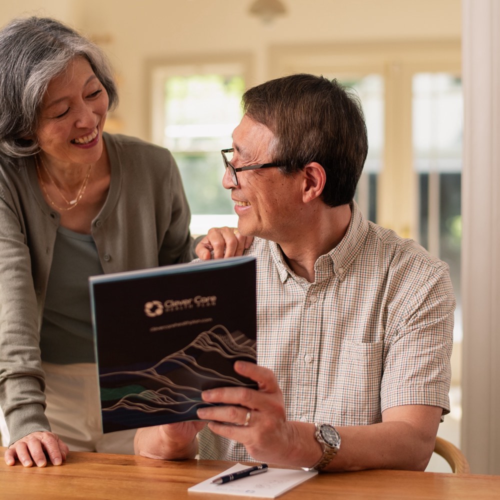 An older couple reviewing a Clever Care plan brochure at home