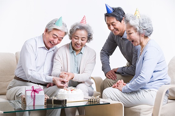 Members celebrating a birthday with cake at a community center
