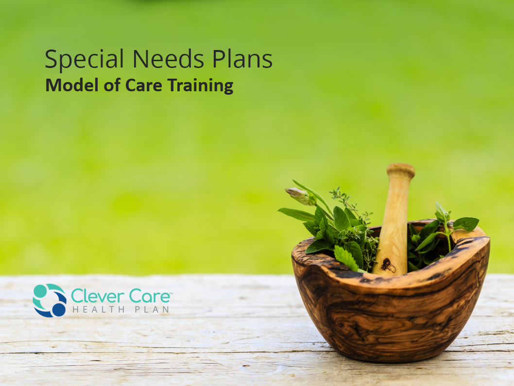 natural wood mortar and pestle with green herbs on a wood surface before a field of mottled green