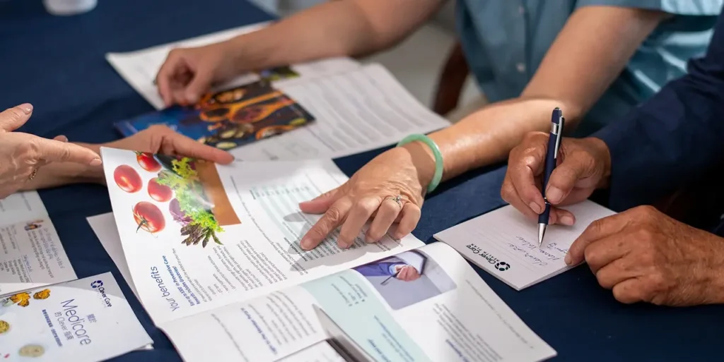 Brokers reviewing Clever Care plan materials with members at a table