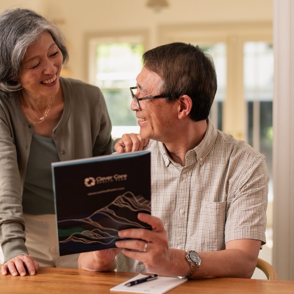 A senior couple reviewing a Clever Care plan booklet at home