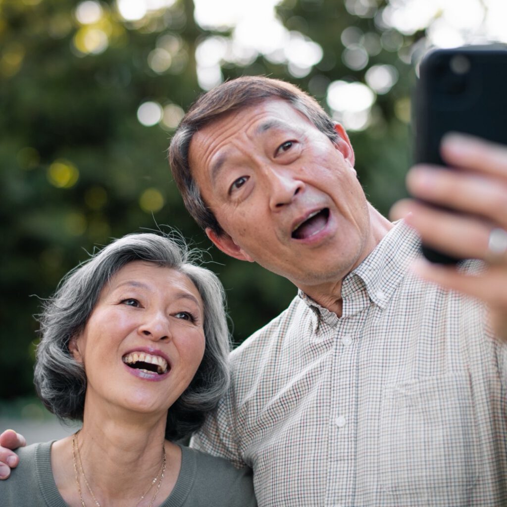 A senior couple taking a selfie together outdoors
